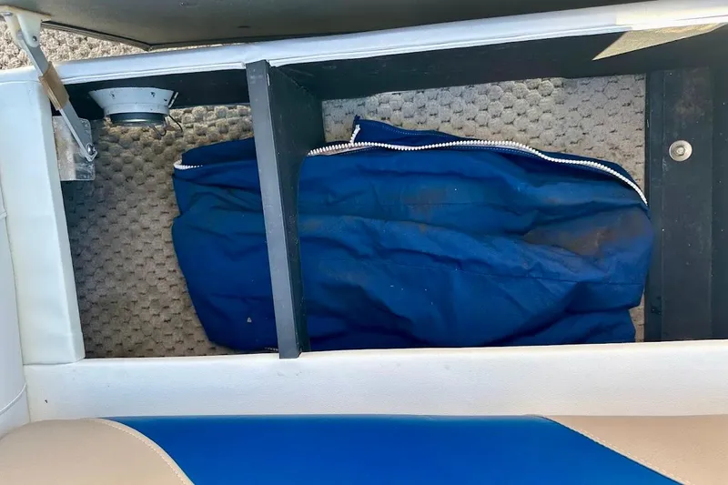 Slide: The Image of Storage compartment in a 2004 Crest 2200 Family DL boat with blue fabric bag. - 18