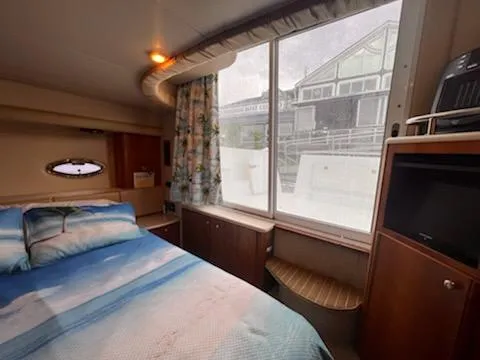 Slide: The Image of Interior of 2004 Meridian 459 Motoryacht bedroom with large window and cozy decor. - 18