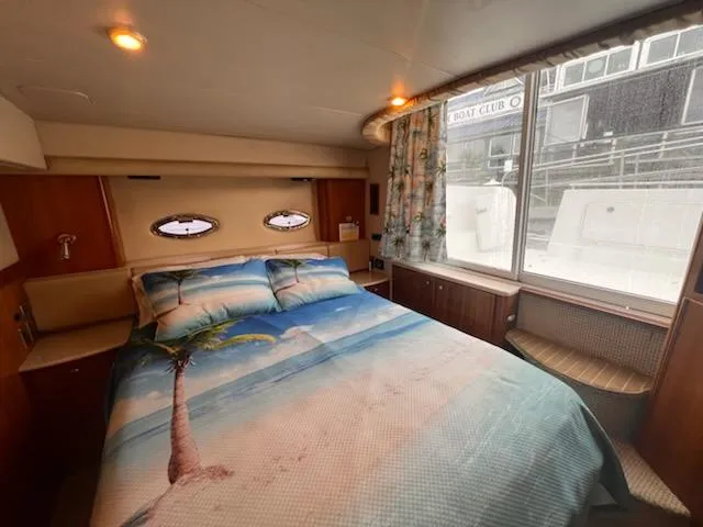 Slide: The Image of Cozy bedroom in 2004 Meridian 459 Motoryacht with beach-themed bedding and large window view. - 19