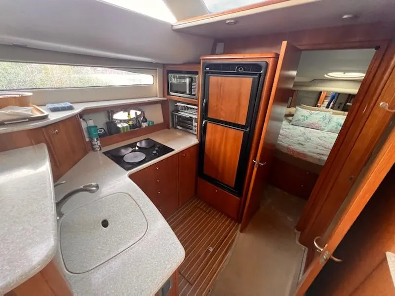Slide: The Image of 2004 Meridian 459 Motoryacht interior kitchen with modern appliances and cozy bedroom. - 20
