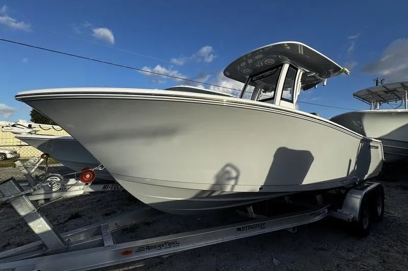 The Image of 2026 Sportsman Open 212 Center Console boat on trailer under blue sky. - 1