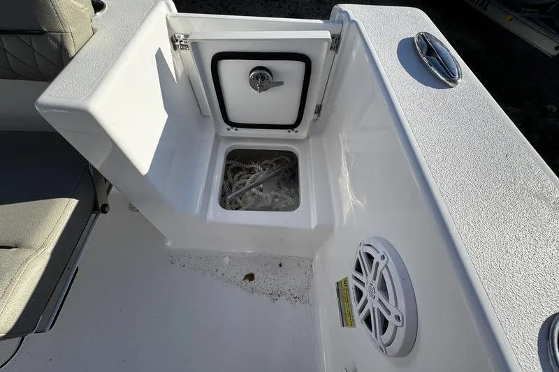 Slide: The Image of 2026 Sportsman Open 212 Center Console boat storage compartment with speaker and seating. - 24