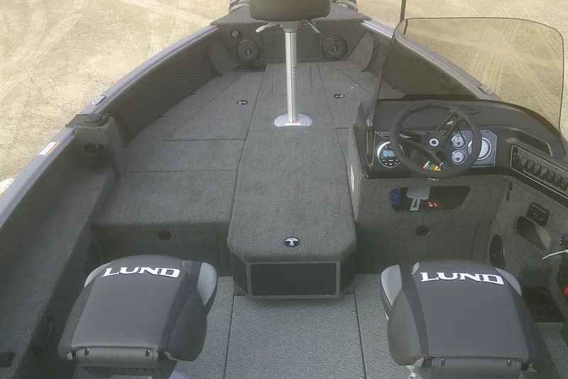 Slide: The Image of 2026 Lund 1875 Impact XS SS boat interior with steering console and seating. - 3