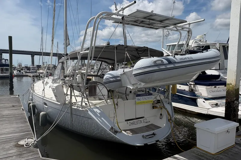 Slide: The Image of Jeanneau Sun Odyssey 45.2 sailboat docked, featuring a dinghy and marina backdrop. - 2