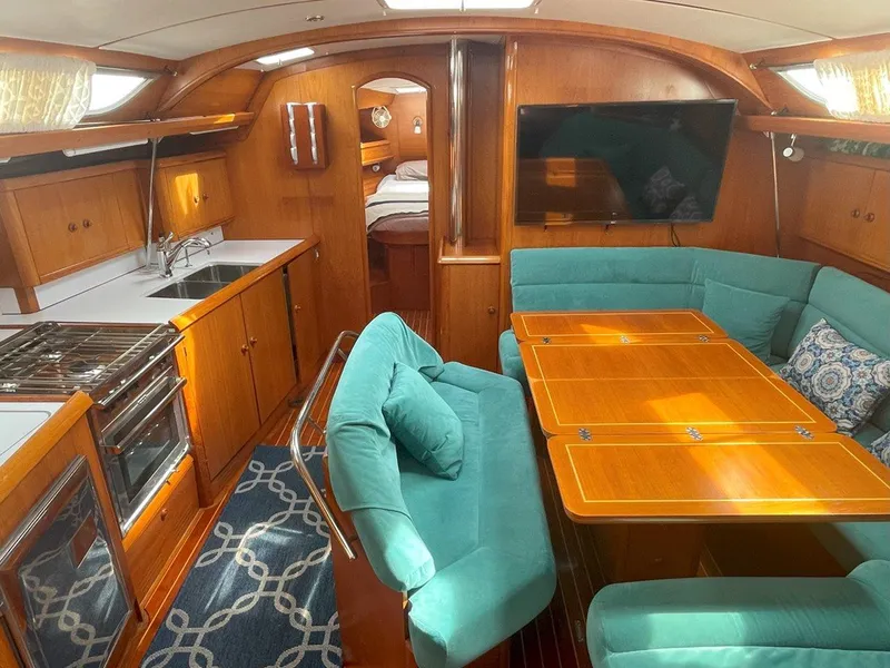 Slide: The Image of Interior of 1998 Jeanneau Sun Odyssey 45.2 yacht with kitchen, seating, and dining area. - 23