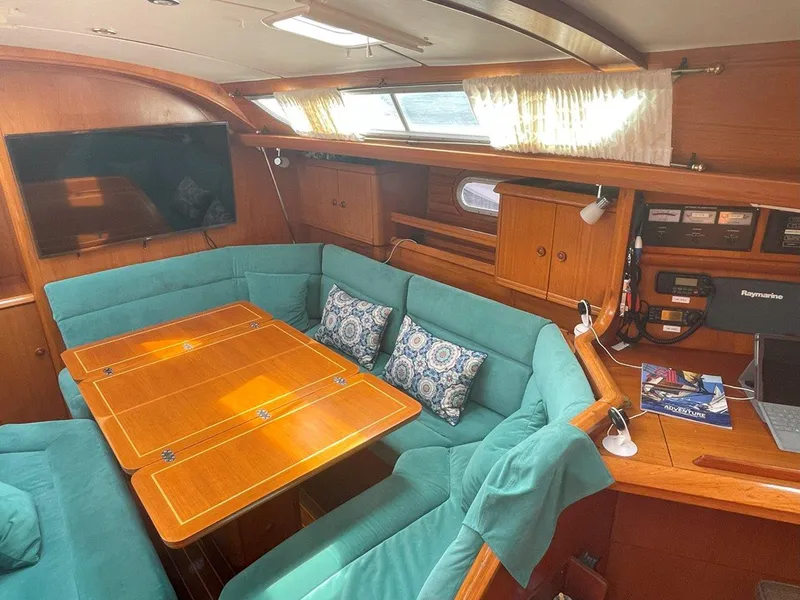 Slide: The Image of Interior of 1998 Jeanneau Sun Odyssey 45.2 yacht with teal seating and wooden table. - 24