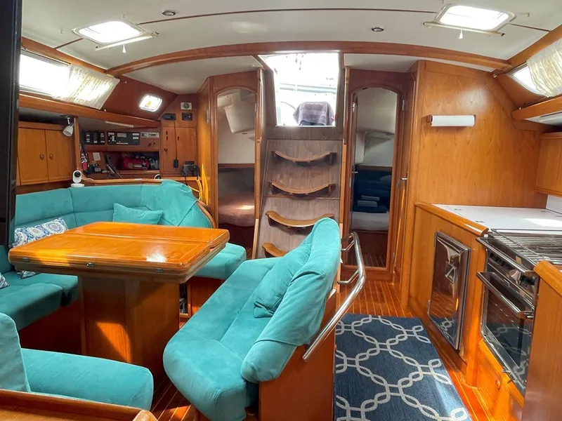 Slide: The Image of Interior of 1998 Jeanneau Sun Odyssey 45.2 sailboat with teal seating and wooden finishes. - 26