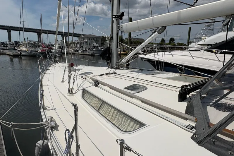 Slide: The Image of 1998 Jeanneau Sun Odyssey 45.2 sailboat docked at a marina under a cloudy sky. - 3