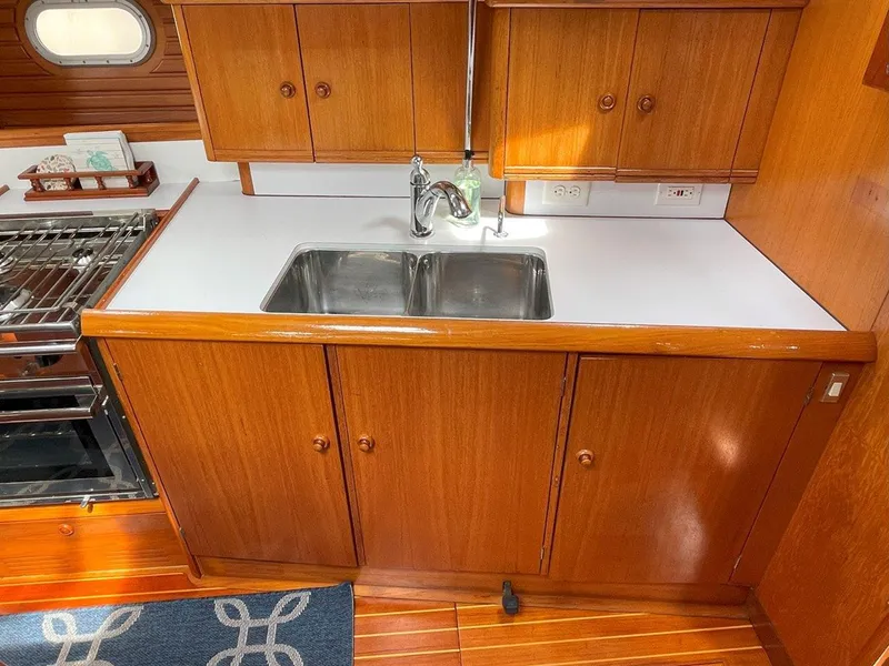 Slide: The Image of Galley kitchen in 1998 Jeanneau Sun Odyssey 45.2 sailboat with wooden cabinetry and double sink. - 30