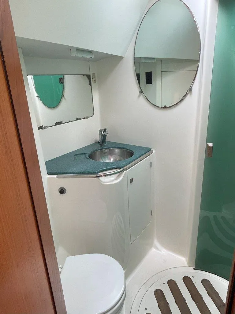 Slide: The Image of Bathroom interior of 1998 Jeanneau Sun Odyssey 45.2 yacht, featuring sink, mirror, and toilet. - 35