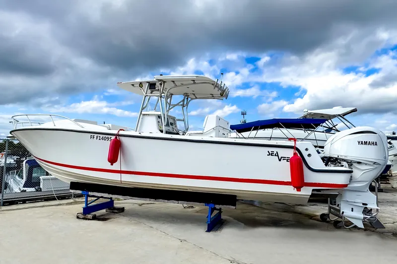 Slide: The Image of 2004 SeaVee 340i Cuddy boat with Yamaha engines on a stand, under cloudy sky. - 0