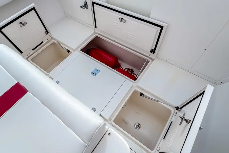 Slide: The Image of 2004 SeaVee 340i Cuddy boat storage compartments with open hatches and visible red equipment. - 15