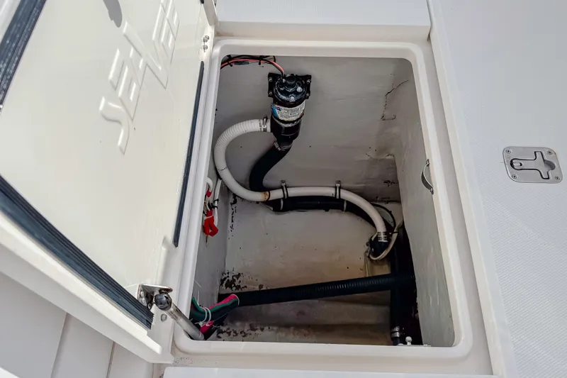 Slide: The Image of 2004 SeaVee 340i Cuddy storage compartment with visible plumbing and wiring. - 16