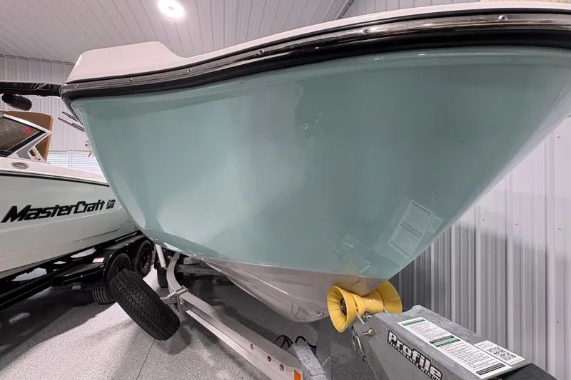 Slide: The Image of 2023 Yamaha Boats 222 FSH Sport in storage, side view with American flag. - 10