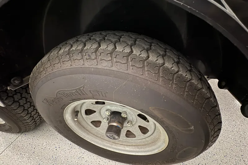 Slide: The Image of Trailer tire for 2023 Yamaha Boats 222 FSH Sport, showcasing tread pattern and wheel rim. - 21