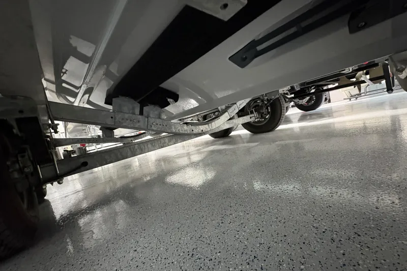 Slide: The Image of 2023 Yamaha Boats 222 FSH Sport hull on trailer, close-up view. - 22