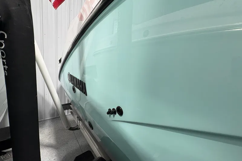 Slide: The Image of Close-up of 2023 Yamaha Boats 222 FSH Sport engine component in a garage setting. - 33