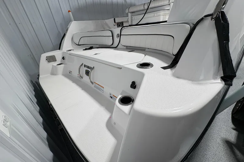 Slide: The Image of 2023 Yamaha Boats 222 FSH Sport interior with seating and rod holders in a storage area. - 40