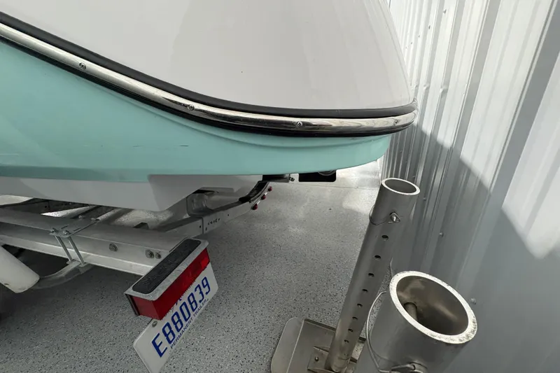 Slide: The Image of 2023 Yamaha Boats 222 FSH Sport in a showroom, light blue hull, on a trailer. - 5