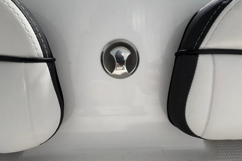 Slide: The Image of 2023 Yamaha Boats 222 FSH Sport interior seating with white upholstery and black accents. - 56