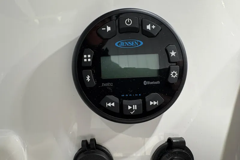 Slide: The Image of 2023 Yamaha Boats 222 FSH Sport interior with white seating and storage compartments. - 80