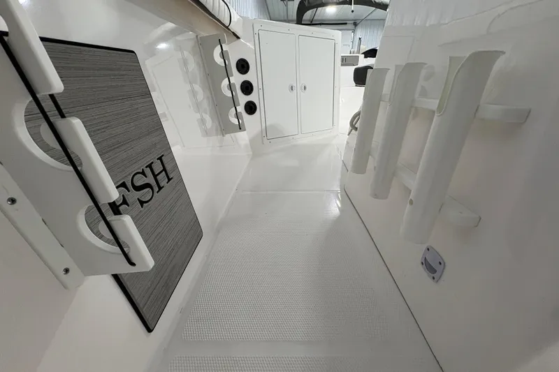 Slide: The Image of 2023 Yamaha Boats 222 FSH Sport interior seating with white upholstery and black trim. - 86