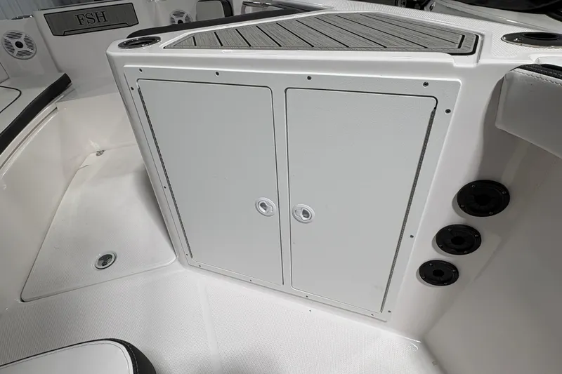 Slide: The Image of 2023 Yamaha Boats 222 FSH Sport interior storage compartment with seating and speaker. - 95