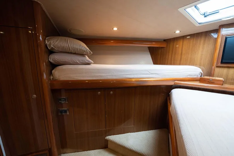 Slide: The Image of Luxurious cabin interior of 2007 Viking 64 Convertible yacht with wooden finishes and bedding. - 13