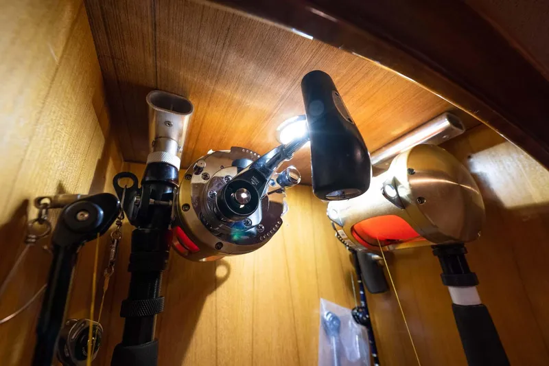 Slide: The Image of Fishing rods and reels stored in a wooden compartment on a 2007 Viking 64 Convertible yacht. - 18
