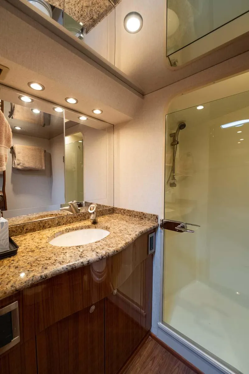 Slide: The Image of Luxurious bathroom in 2007 Viking 64 Convertible yacht with granite countertop and glass shower. - 25