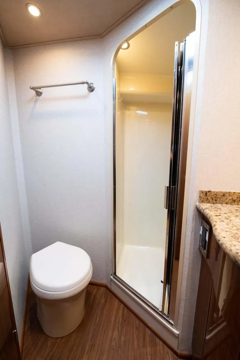 Slide: The Image of 2007 Viking 64 Convertible yacht bathroom with shower, toilet, and granite countertop. - 28