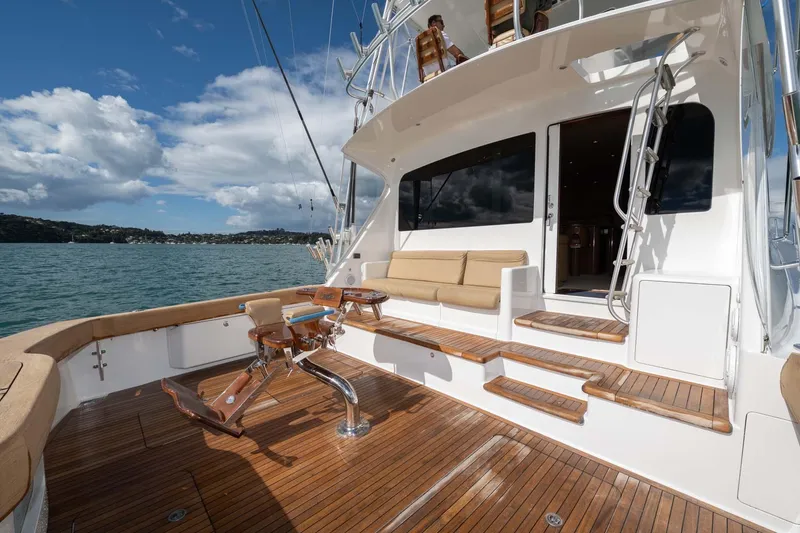 Slide: The Image of 2007 Viking 64 Convertible yacht with spacious deck and seating, set against a scenic water backdrop. - 33