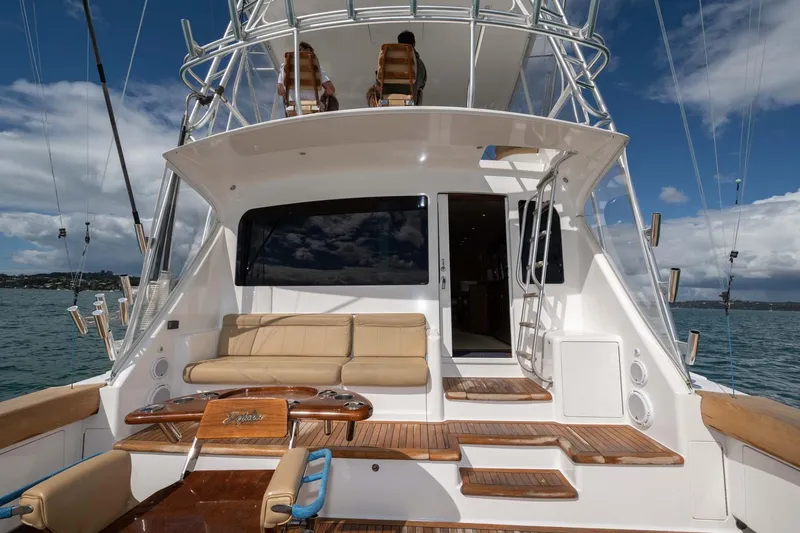 Slide: The Image of 2007 Viking 64 Convertible yacht with spacious deck and seating, set against a scenic ocean backdrop. - 36