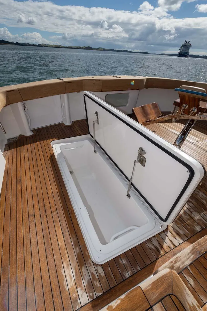 Slide: The Image of 2007 Viking 64 Convertible yacht deck with open storage compartment, wooden flooring, and ocean view. - 37