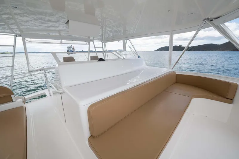 Slide: The Image of 2007 Viking 64 Convertible yacht interior with tan seating, overlooking serene waters and distant islands. - 47