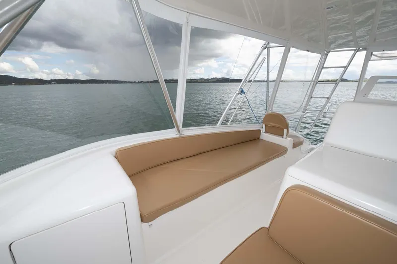 Slide: The Image of 2007 Viking 64 Convertible yacht interior with tan seating, overlooking calm waters. - 49