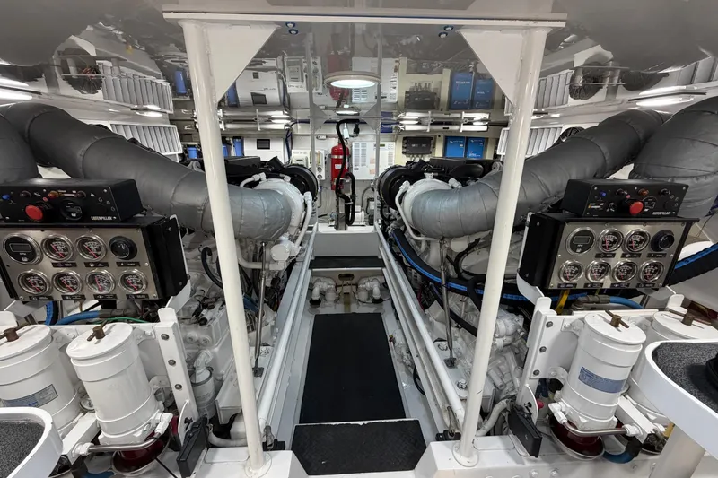 Slide: The Image of Engine room of a 2007 Viking 64 Convertible yacht, featuring dual engines and control panels. - 83