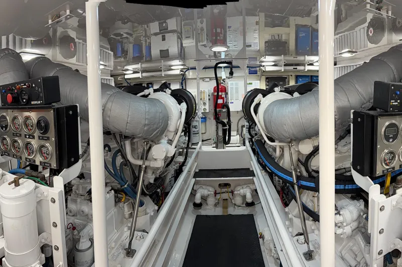 Slide: The Image of Engine room of a 2007 Viking 64 Convertible yacht, featuring dual engines and control panels. - 95