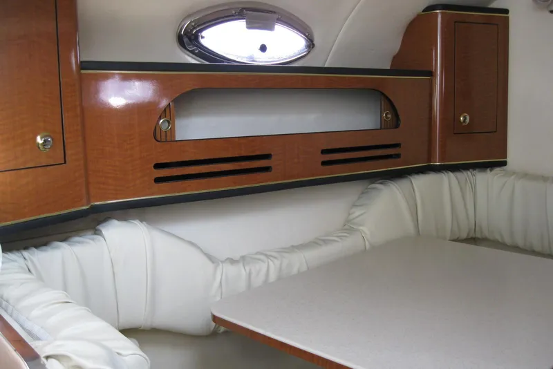 Slide: The Image of Interior of 2002 Sea Ray Sundancer 280 with cushioned seating and table. - 27