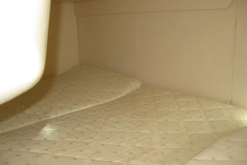 Slide: The Image of 2002 Sea Ray Sundancer 280 cabin interior with wood paneling and cushioned seating. - 30