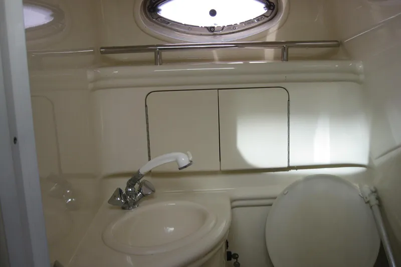 Slide: The Image of 2002 Sea Ray Sundancer 280 bathroom with toilet and sink, compact marine design. - 39