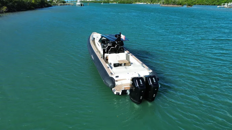 Slide: The Image of Technohull 47 Omega 2023 on calm water with dual outboard engines. - 11
