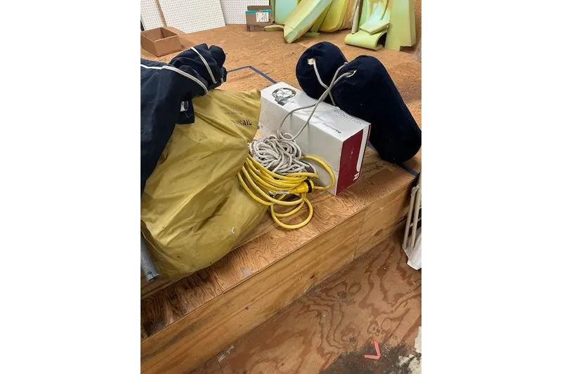 Slide: The Image of Sailing equipment including ropes and fenders on wooden floor, Ericson 33, 1982. - 13