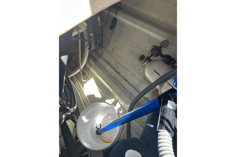 Slide: The Image of Interior of 1982 Ericson 33 sailboat engine compartment with hoses and equipment. - 15