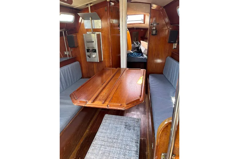 Slide: The Image of Interior of 1982 Ericson 33 sailboat with wooden table and blue seating. - 19