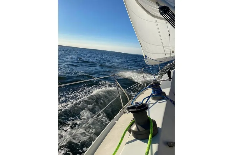 Slide: The Image of Sailing on 1982 Ericson 33 yacht, ocean view, clear skies, and vibrant ropes. - 20