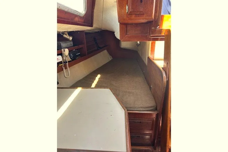 Slide: The Image of Cozy cabin interior of 1982 Ericson 33 sailboat with wooden furnishings and a cushioned berth. - 7