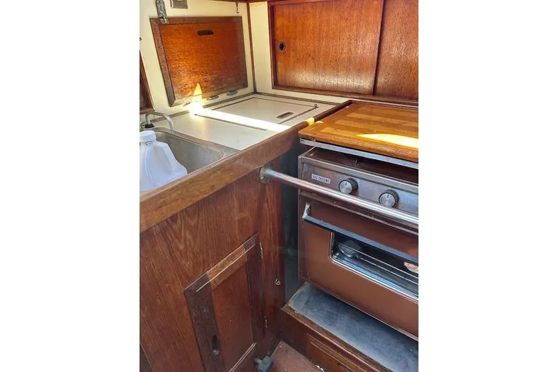 Slide: The Image of 1982 Ericson 33 yacht kitchen with wooden cabinetry and stove. - 8