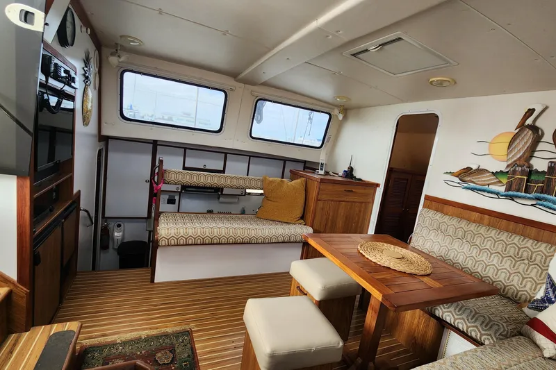 Slide: The Image of Interior of 2005 Endeavour 44 TrawlerCat with cozy seating and wooden table. - 2