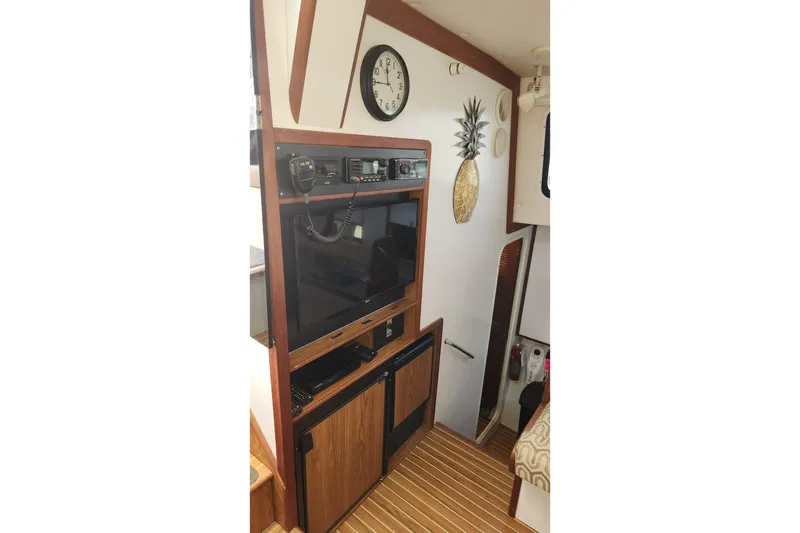 Slide: The Image of 2005 Endeavour 44 TrawlerCat interior with electronics, clock, and pineapple wall decor. - 20